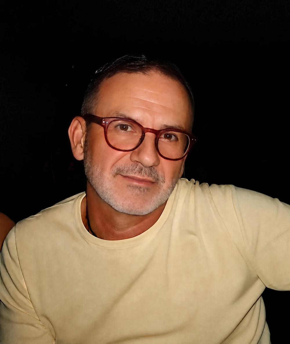 Nebojsa Visnjic wearing glasses and a pale yellow shirt